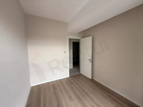 Geniş pencereli, aydınlık ve modern bir boş yatak odası iç mekanı.