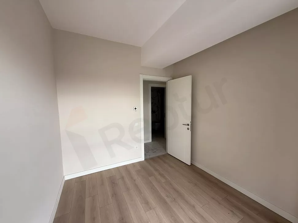 Geniş pencereli, aydınlık ve modern bir boş yatak odası iç mekanı.