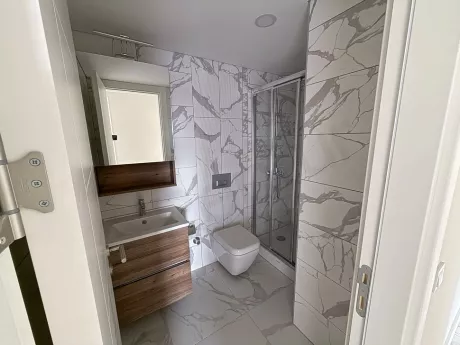 Modern ve şık tasarıma sahip, kaliteli armatürlerle donatılmış geniş bir banyo görseli.