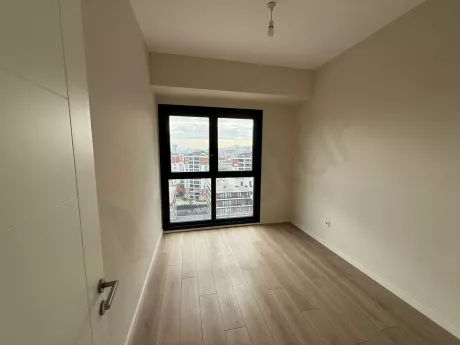 Modern mimariye sahip, gün ışığı alan geniş ve ferah bir yatak odası alanı.
