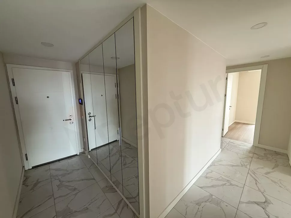 Modern bir binada yer alan 3+1 dairenin giriş kapısı ve antre alanı.