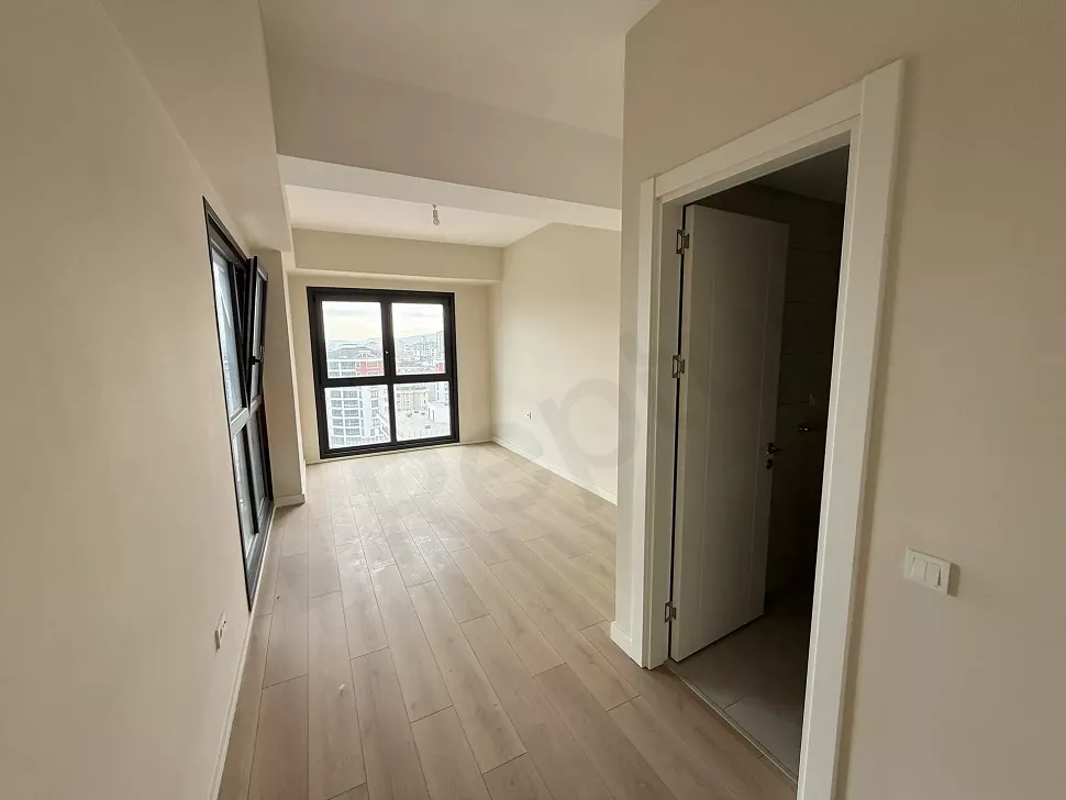 Modern tasarımlı, geniş pencereli ve aydınlık boş yatak odası alanı.