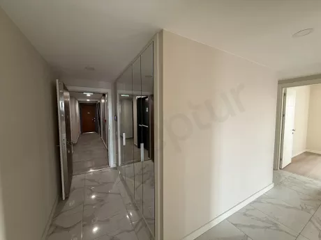 Modern bir apartman dairesinin giriş kapısı ve antre alanı görünümü.