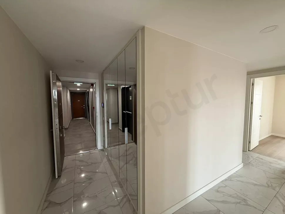 Modern bir apartman dairesinin giriş kapısı ve antre alanı görünümü.