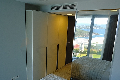 Bodrum'da satılık lüks villanın şık ve modern mobilyalı yatak odası görseli.