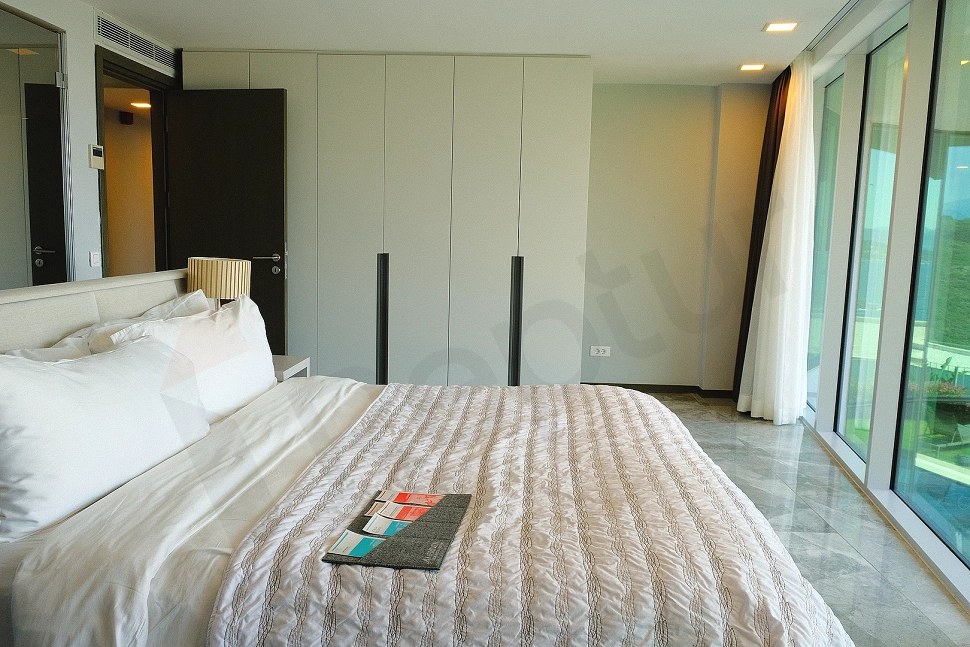 Modern mobilyalarla dekore edilmiş, ferah ve aydınlık lüks villa yatak odası görseli.