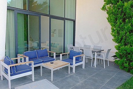 Bodrum'daki lüks villanın modern mobilyalarla döşenmiş, geniş ve deniz manzaralı teras alanı.