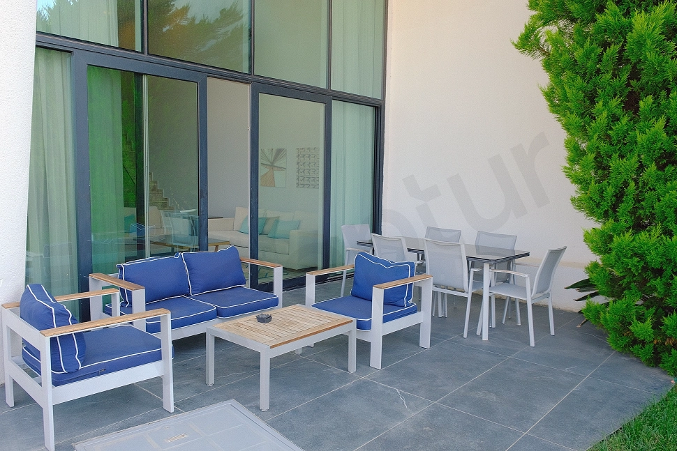 Bodrum'daki lüks villanın modern mobilyalarla döşenmiş, geniş ve deniz manzaralı teras alanı.