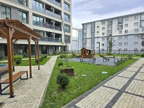 Renkli kaydıraklar ve güvenli zeminli modern açık hava çocuk parkı alanı.