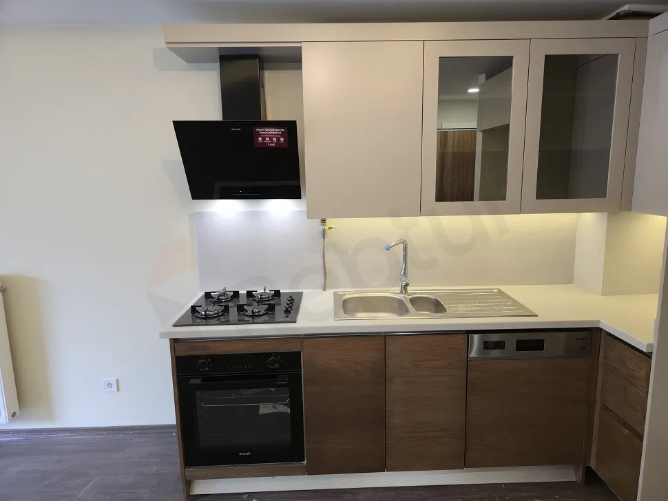 Modern ve ferah tasarıma sahip bir daire içindeki açık mutfak alanı.