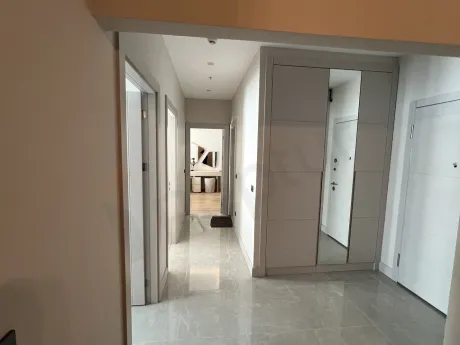 Modern tasarımlı, ahşap basamaklı daire içi merdiven görünümü.