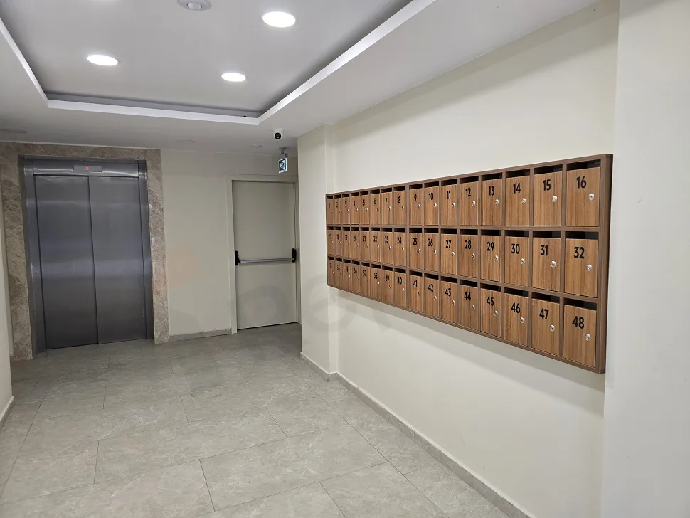 Modern ve şık tasarımlı, geniş bir rezidans lobisi ve karşılama alanı.
