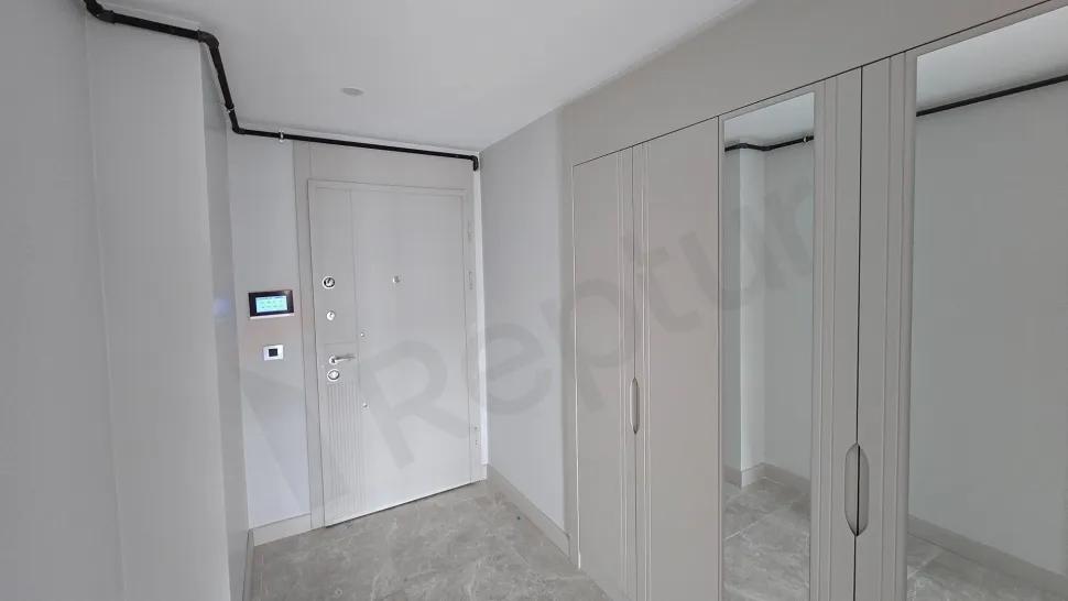 Modern ve geniş bir dairenin giriş holü ve antre alanı.