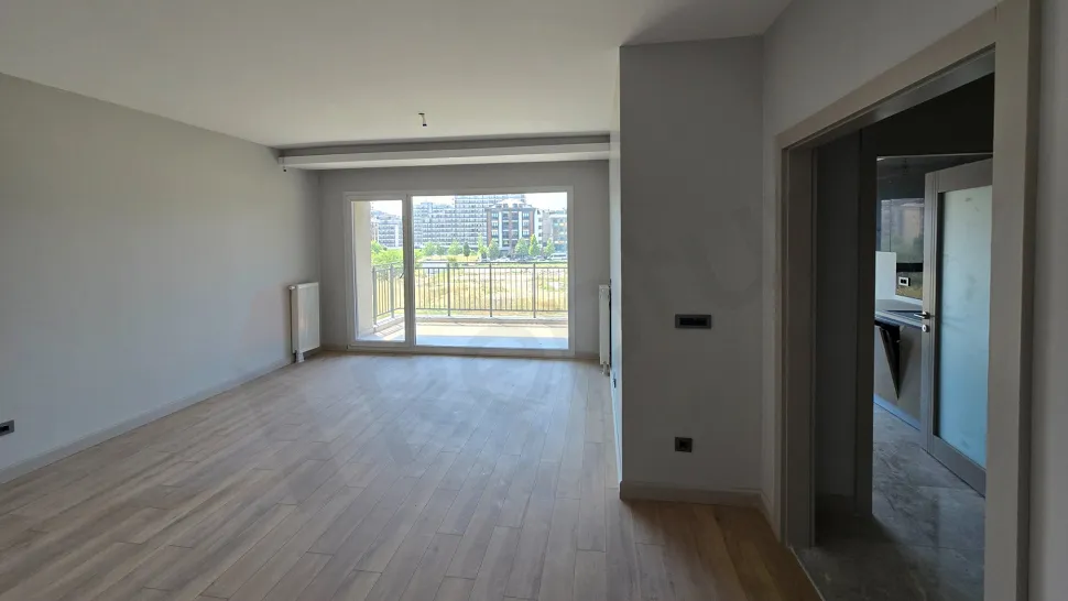 Geniş pencereli, modern ve aydınlık bir dairenin ferah oturma odası alanı.