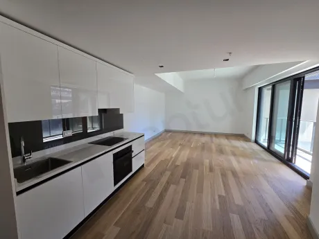 Şişli'deki lüks bir dairenin modern ve geniş tasarımlı açık plan mutfak alanı.
