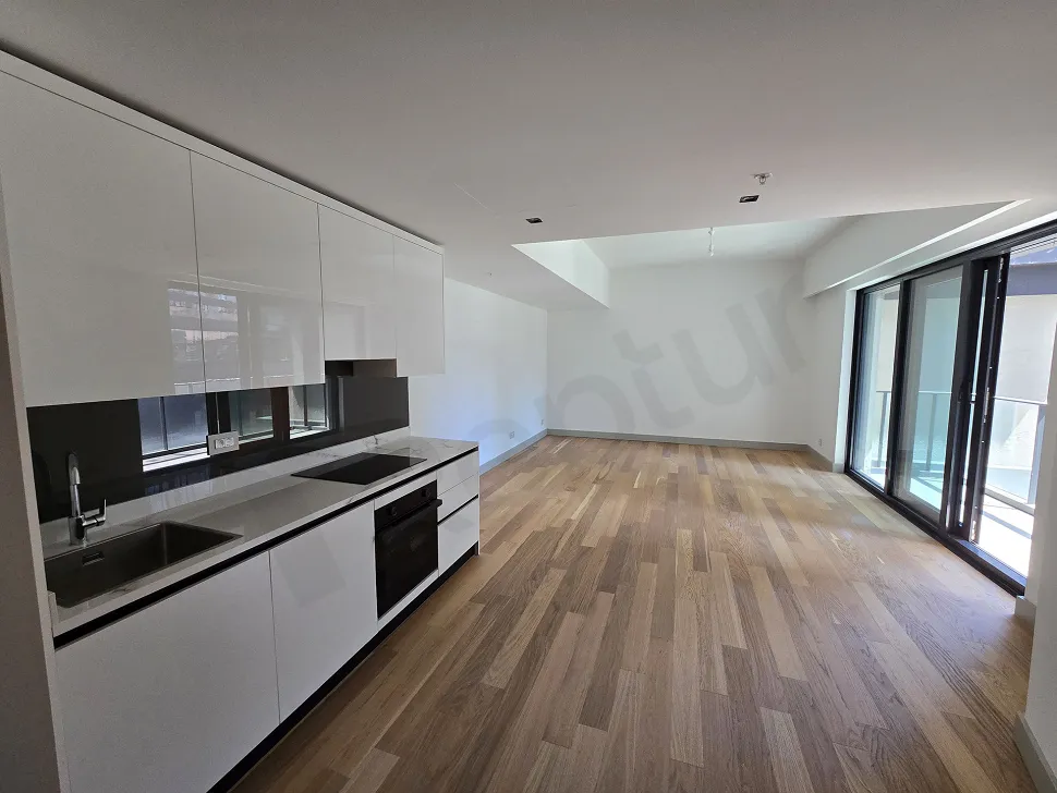 Şişli'deki lüks bir dairenin modern ve geniş tasarımlı açık plan mutfak alanı.