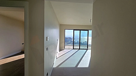 Geniş pencereli, modern ve aydınlık oturma odası iç mekanı.