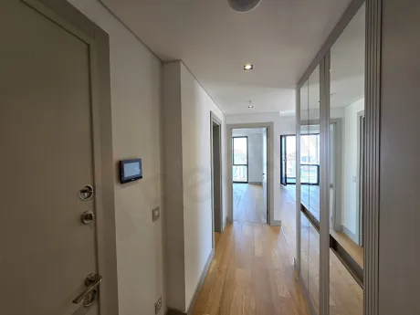 Modern bir rezidans dairesinin giriş holü ve çelik kapısı.