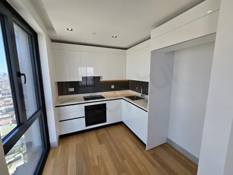 Modern tasarımlı, şık dolaplara ve geniş tezgaha sahip mutfak alanı.