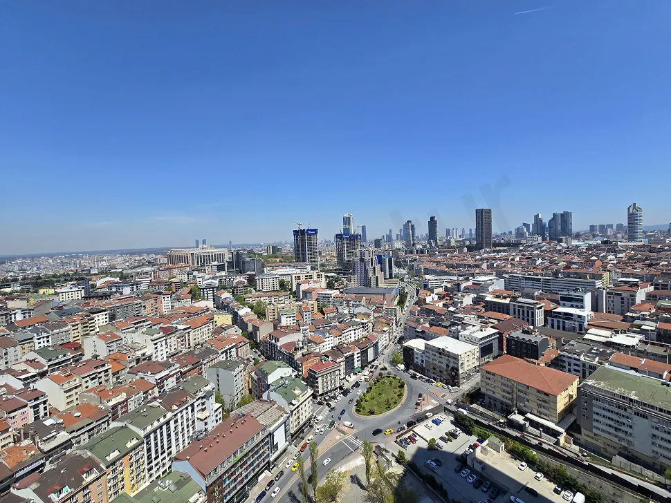 Şehir manzarasına açılan modern ve geniş bir apartman balkonu.