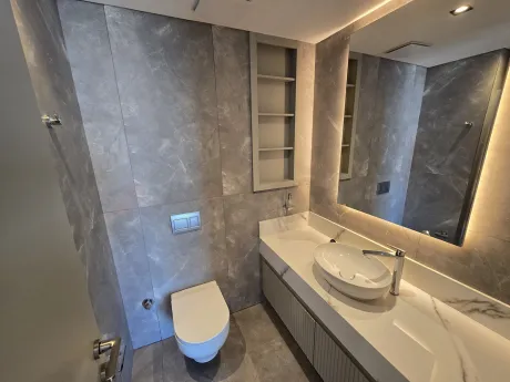 Modern ve şık tasarımlı, geniş seramik döşemeli banyo alanı.