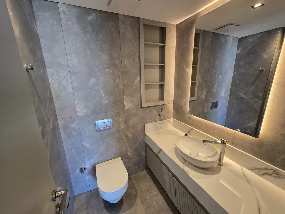 Modern ve şık tasarımlı, geniş seramik döşemeli banyo alanı.