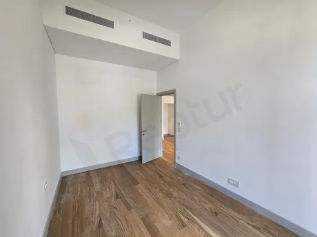 Modern tasarımlı, geniş pencereli ve gün ışığı alan aydınlık bir yatak odası görseli.