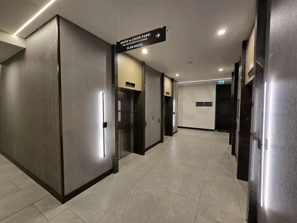 Modern ve sade bir tasarıma sahip, aydınlık daire koridoru.