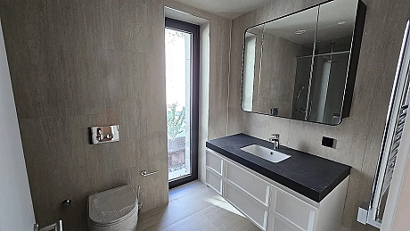 Modern ve şık tasarımlı, geniş ve aydınlık bir banyo alanı.