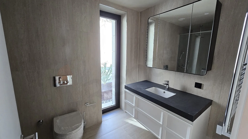 Modern ve şık tasarımlı, geniş ve aydınlık bir banyo alanı.
