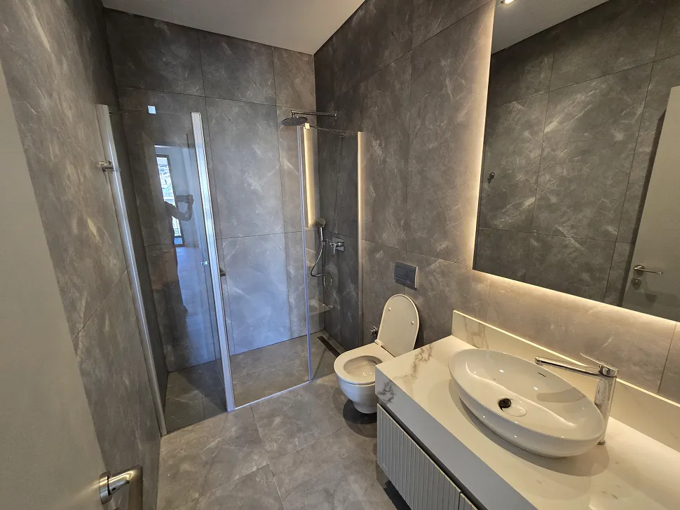 Modern ve şık tasarıma sahip, geniş ve aydınlık bir banyo iç mekanı.
