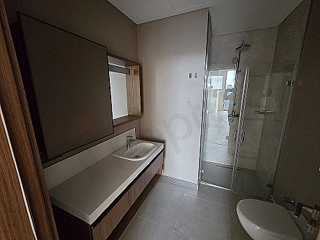 Modern tasarımlı, aydınlık ve ferah banyo iç mekanı. Beyaz seramikler, geniş duş alanı ve şık lavabo.