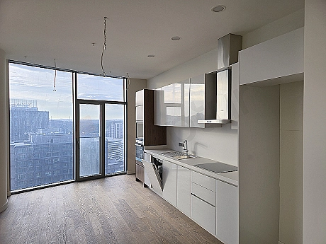 Modern tasarımlı, beyaz mutfak dolapları ve ahşap tezgahı olan aydınlık mutfak.