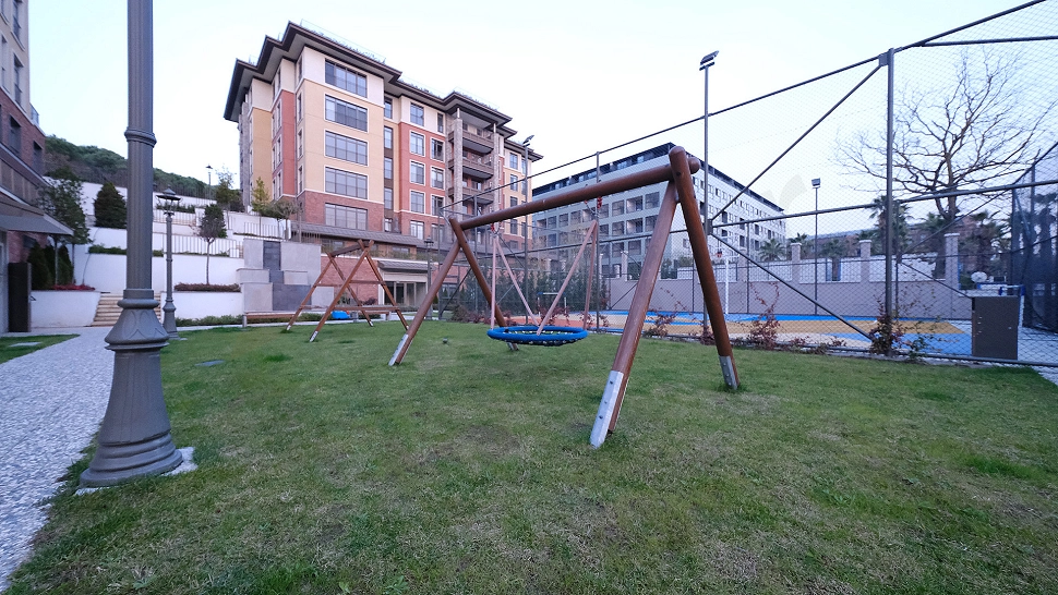 Renkli oyun ekipmanları ile donatılmış çocuk parkı görseli.