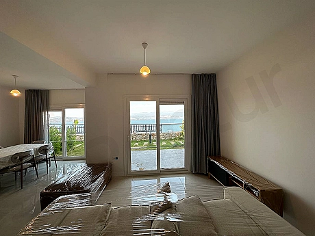 Bodrum'da modern mobilyalarla döşenmiş, geniş ve gün ışığı alan ferah bir oturma odası.
