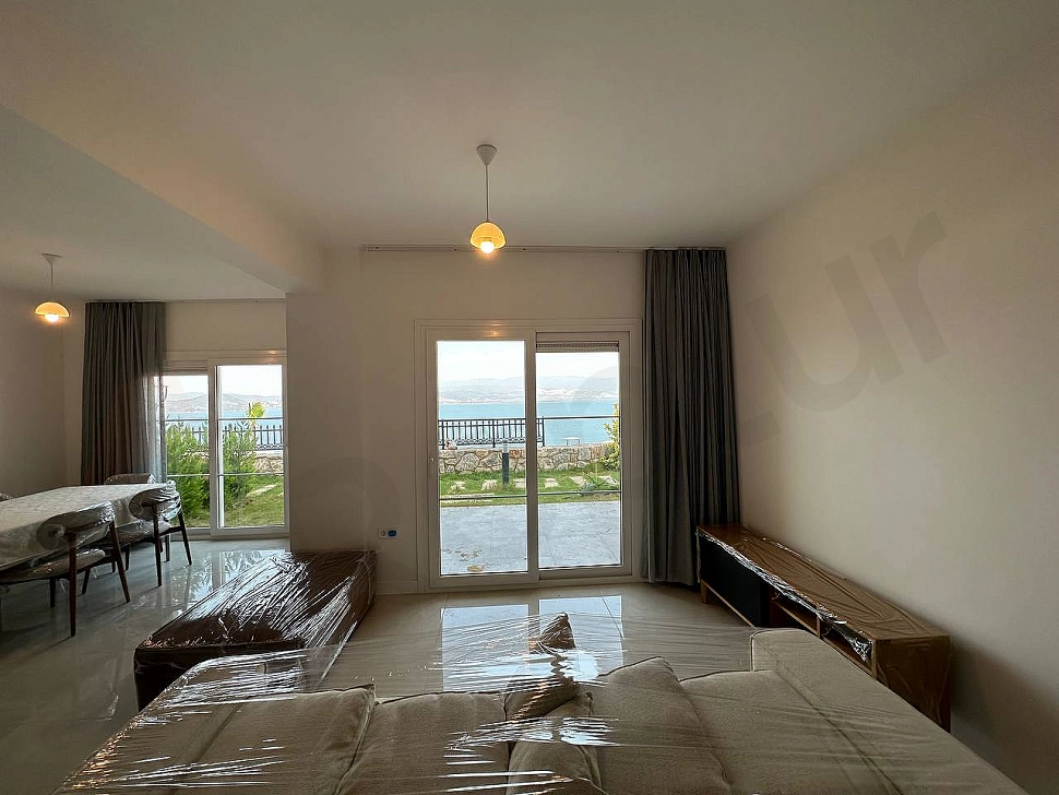 Bodrum'da modern mobilyalarla döşenmiş, geniş ve gün ışığı alan ferah bir oturma odası.