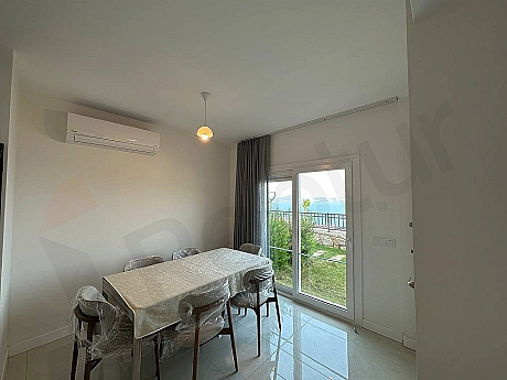 Modern bir yemek masası ve konforlu sandalyelerle dekore edilmiş şık bir yemek odası alanı.