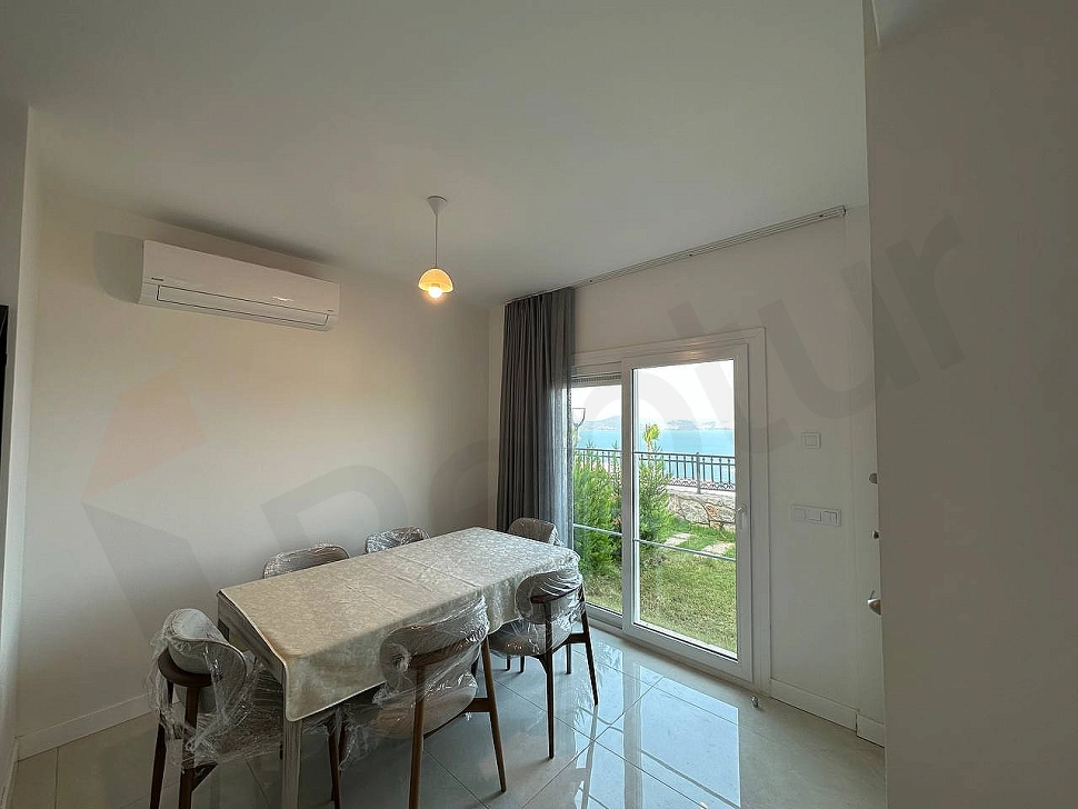Modern bir yemek masası ve konforlu sandalyelerle dekore edilmiş şık bir yemek odası alanı.