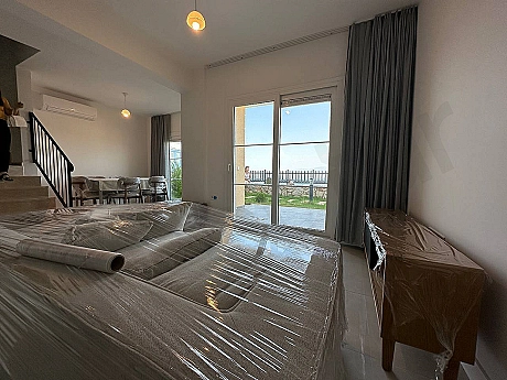 Modern mobilyalarla döşenmiş, geniş ve aydınlık bir oturma odası görseli.