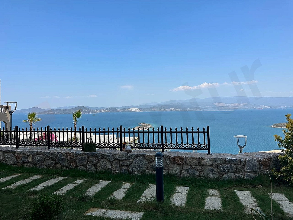 Bodrum'daki modern dubleks evin peyzajlı ve bakımlı yeşil bahçesi.