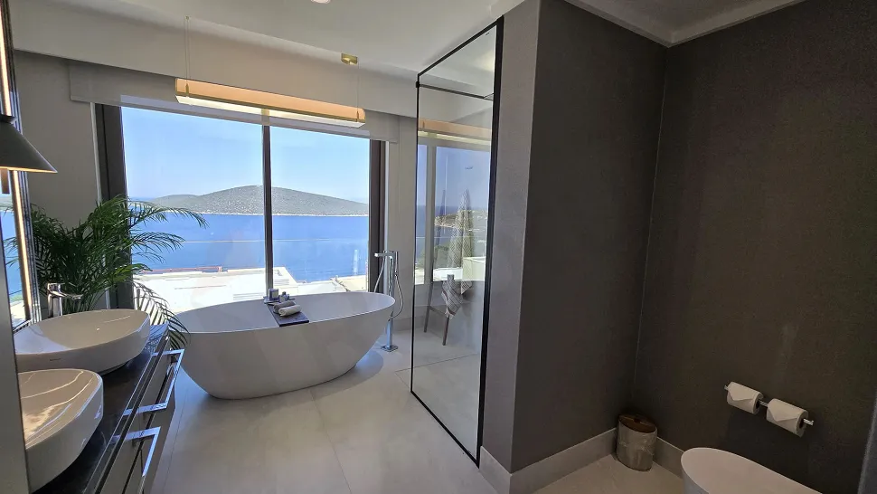 Modern ve geniş tasarımlı, şık vitrifiye ürünlerine sahip banyo alanı.