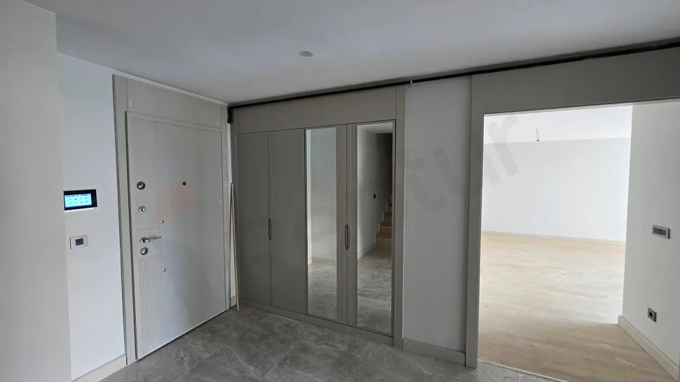 Modern bir binada şık ve geniş daire girişi ile çelik kapı görünümü.