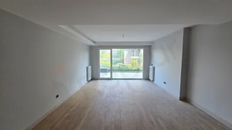 Geniş pencereli ve şehir manzaralı modern bir oturma odası alanı.
