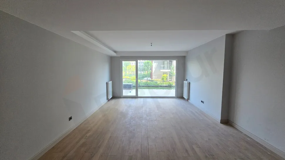 Geniş pencereli ve şehir manzaralı modern bir oturma odası alanı.