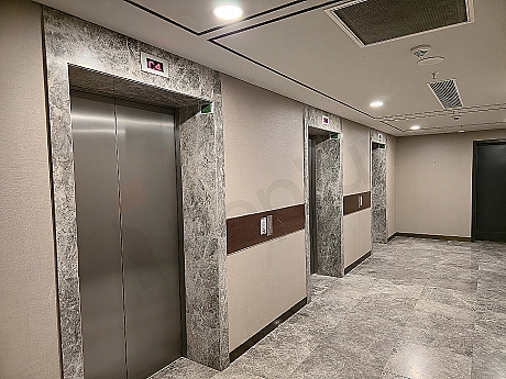 Modern asansör kabini iç mekanı, paslanmaz çelik detaylar, aydınlatma ve kontrol paneli.