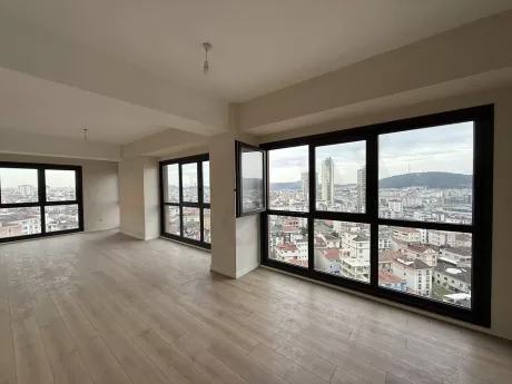 Geniş pencereli, ferah ve modern bir mimariye sahip boş oturma odası alanı.