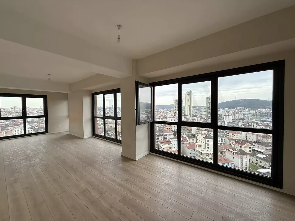 Geniş pencereli, ferah ve modern bir mimariye sahip boş oturma odası alanı.