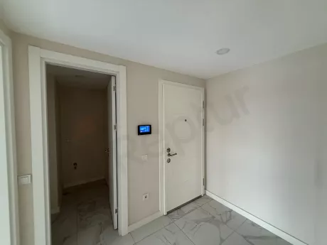 Modern bir dairenin giriş kapısı ve antre alanı görünümü.