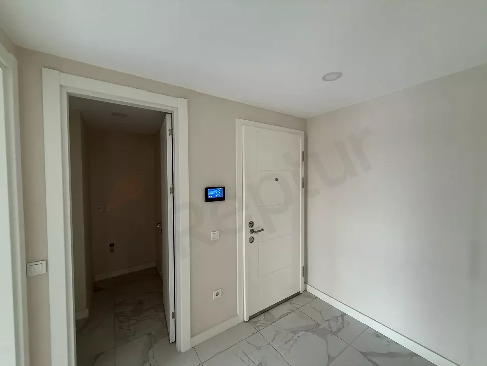 Modern bir dairenin giriş kapısı ve antre alanı görünümü.