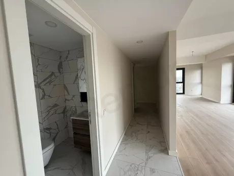 Modern bir binada yer alan geniş ve ferah daire koridoru görünümü.